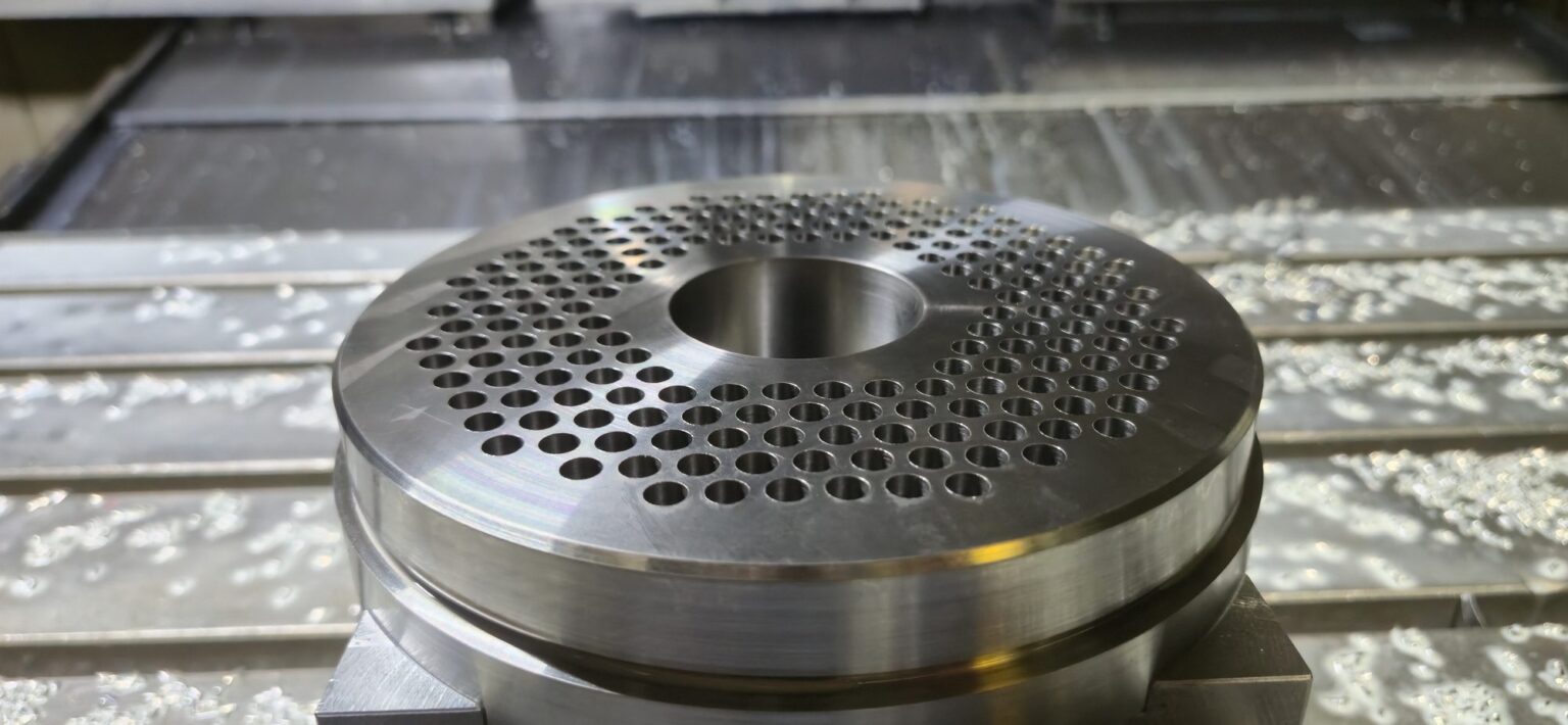 Breaker plate on the mill table after drilling, hole pattern and center bore