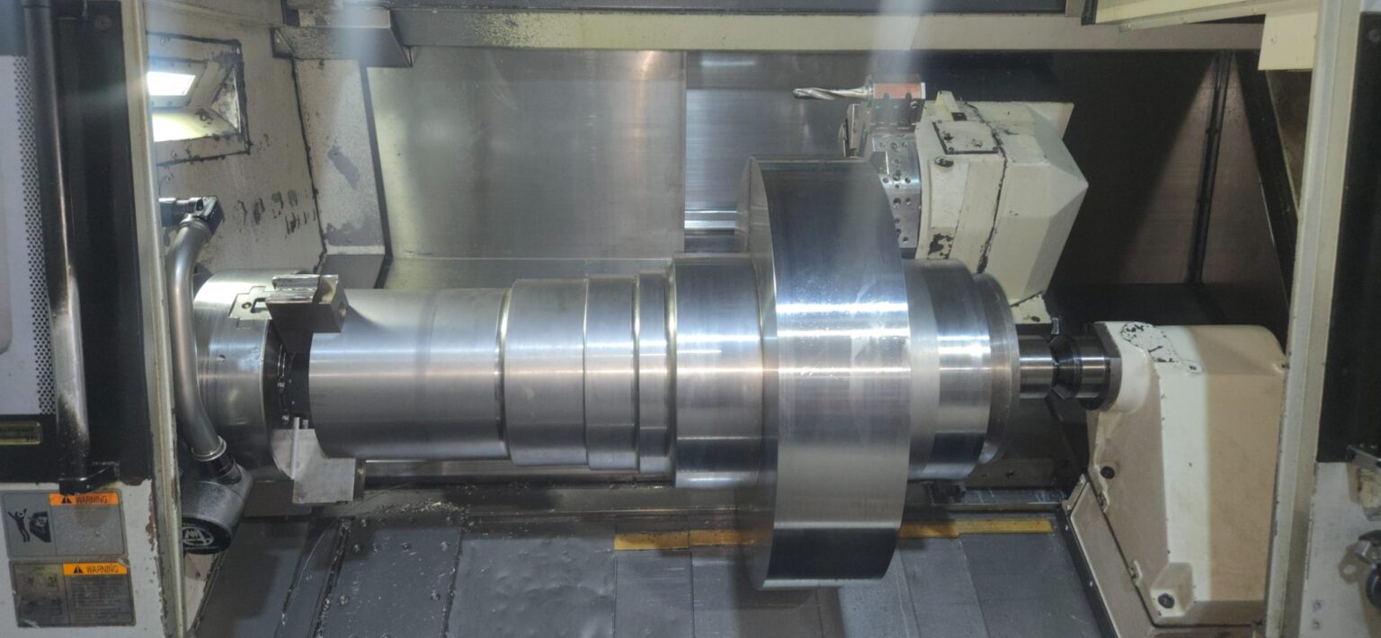 Large diameter industrial thrust shaft undergoing precision CNC turning at Zala Machine Co., showcasing custom shaft manufacturing capabilities for heavy-duty applications.