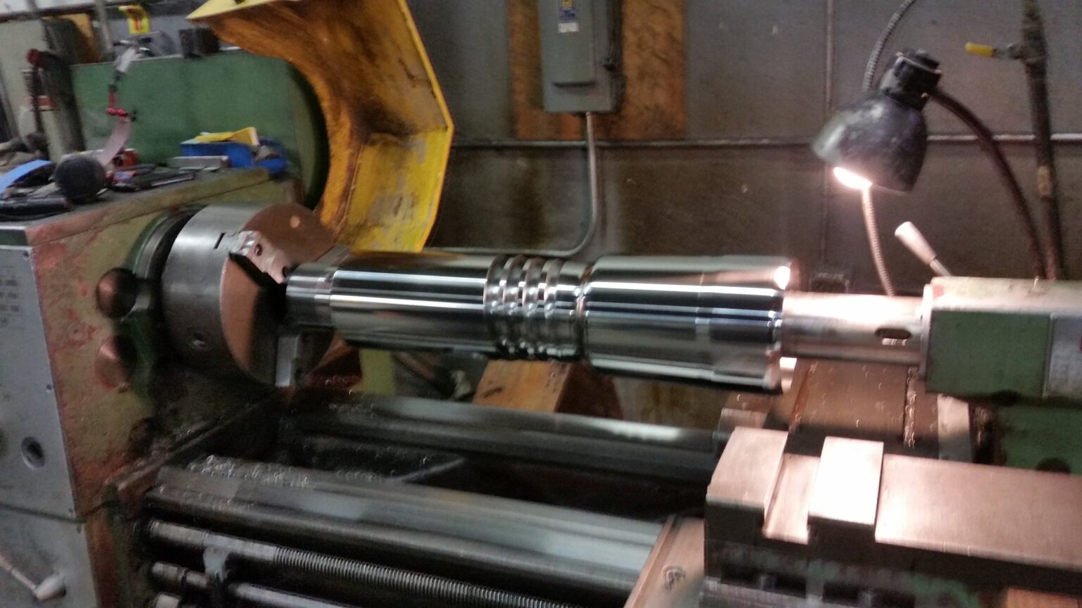 Threaded section cut into a shaft on the manual lathe under the work lamp