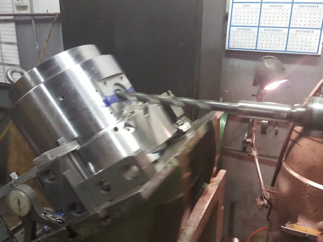 Machined housing with finished bore held in the machine