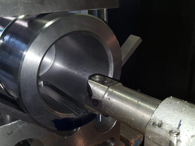 Boring bar cutting a deep bore in a large steel housing