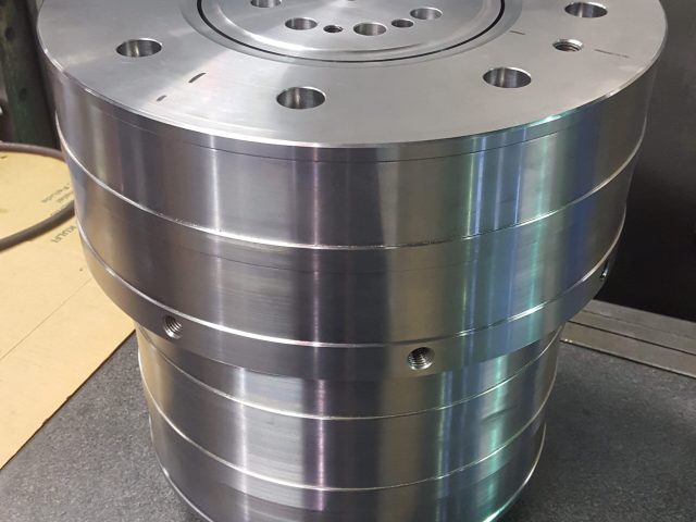 Stepped cylindrical die body with machined steps and bolt holes
