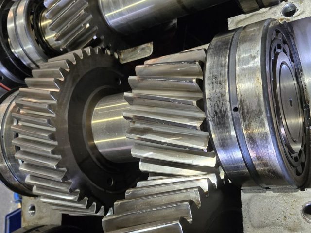 Close-up of helical gear mesh and spherical roller bearing during an industrial gearbox rebuild