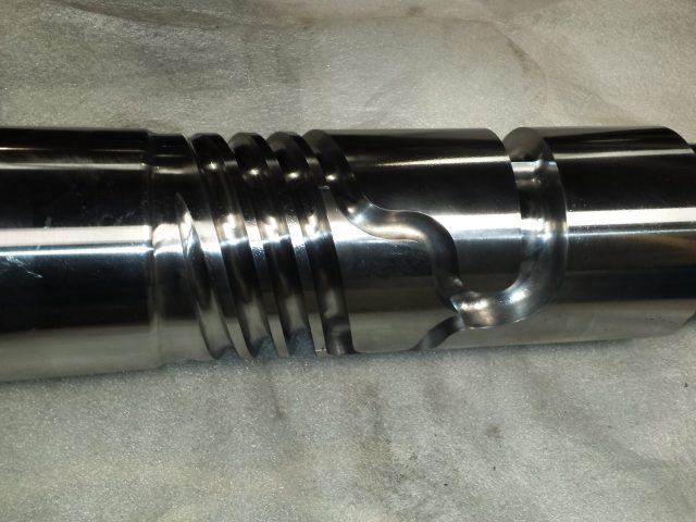 Close view of the barrier flights and mixing flute on a polished 4.5in extruder screw