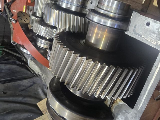 Gear train reassembled and re-timed inside an industrial extruder gearbox housing