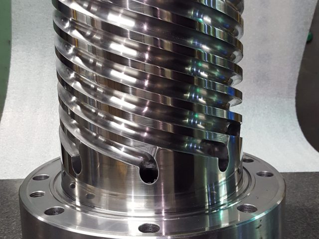 Finished spiral mandrel with helical flow channels and mounting flange