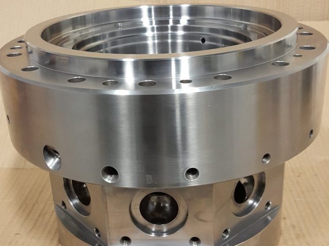 Finished blown film die body, bolt-circle flange above a band of machined side melt ports