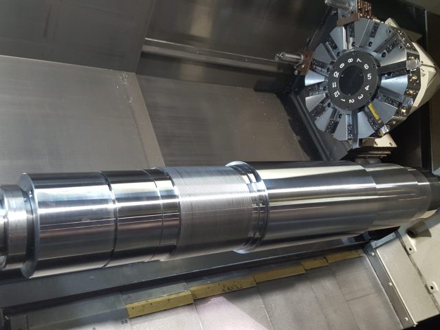 Long splined drive shaft on the lathe bed after CNC turning