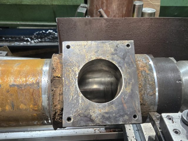 Worn extruder barrel on the engine lathe, square feed port flange and threaded end