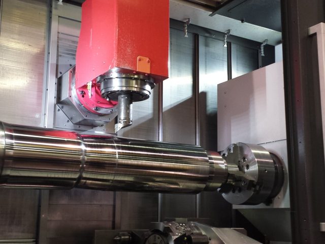 Extruder screw journal held in the mill-turn chuck, full length supported under the milling head