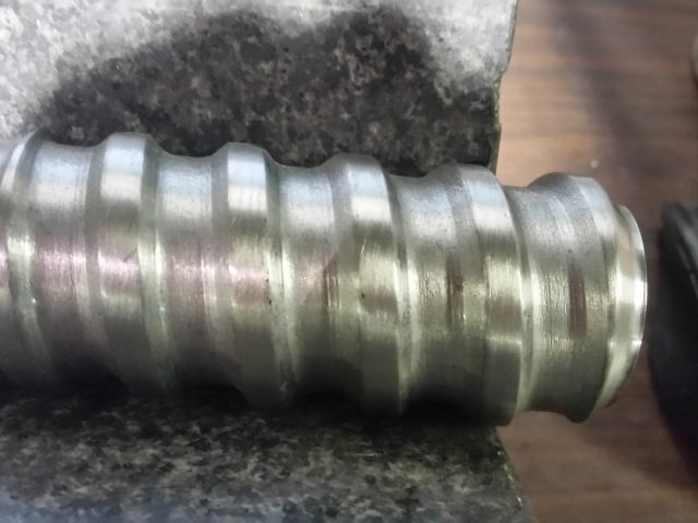 Close view of the deep helical flight cut along an extruder screw's mixing section