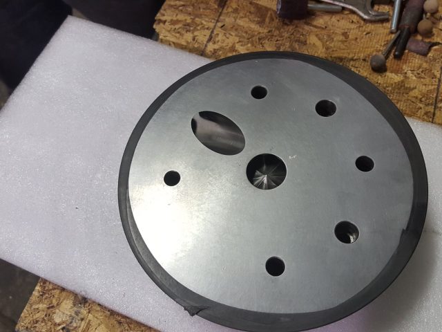 Extrusion die plate with its centre port, bolt holes and elongated melt slot machined through