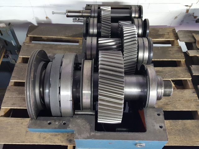 Multi-stage gear drive assembled on its stand, three helical gear sets and shafts stacked out of the case