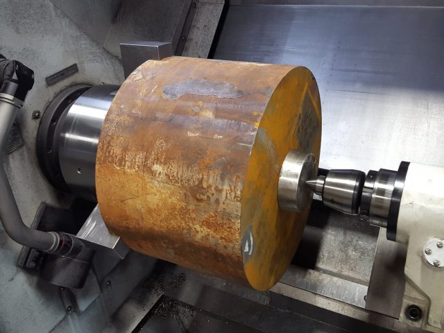 Die block billet chucked in the lathe and supported on a live centre before the first cut