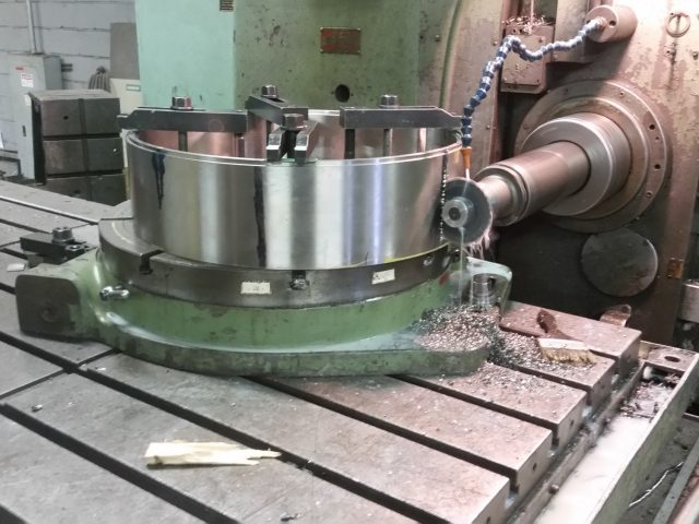 Large steel ring clamped on the horizontal boring mill's rotary table, boring bar engaged