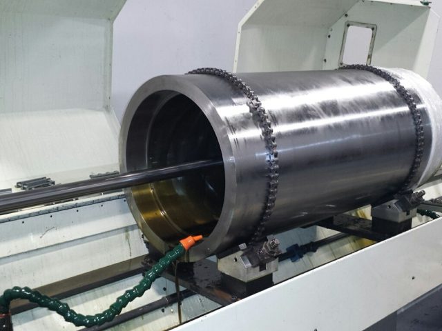 Large cylinder barrel set up on the honing machine with the hone entering the bore