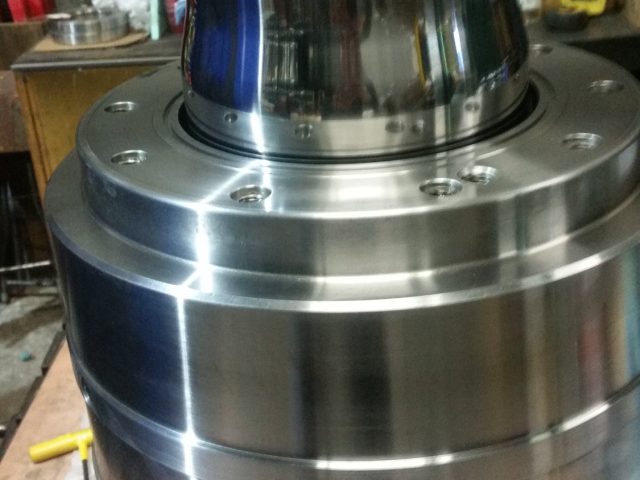 Blown film die housing assembled from its stacked machined sections, polished neck at the top