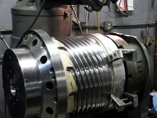 Large barrel housing on the machine, circumferential grooves cut around the body and the flange faced