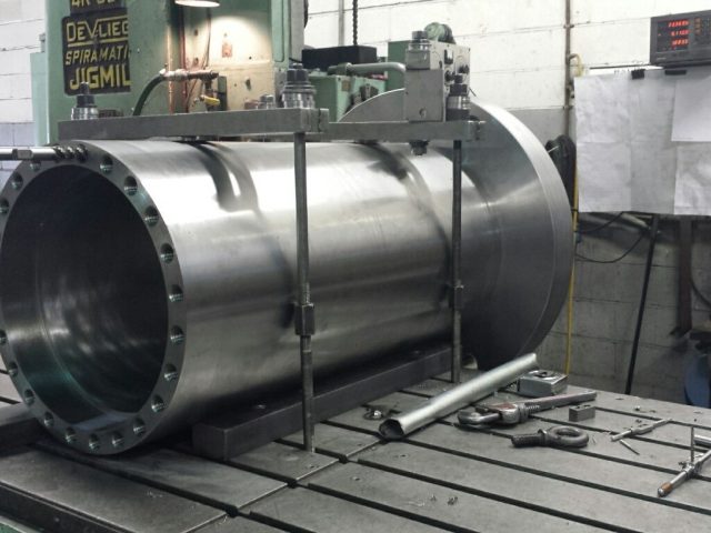 Large cylinder housing clamped on the DeVlieg jig mill, open bore and bolted flange to the front