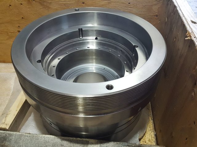 Machined ring housing crated for shipping, stepped bore inside and a threaded band on the outside