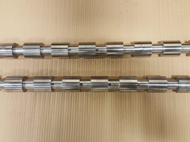 Pair of long shafts machined with splined collars and grooves along the full length