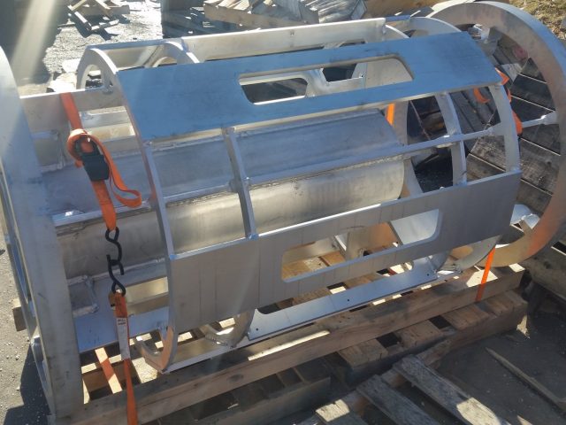 Fabricated cage rotor cylinder strapped on a pallet, slotted body between its end rings
