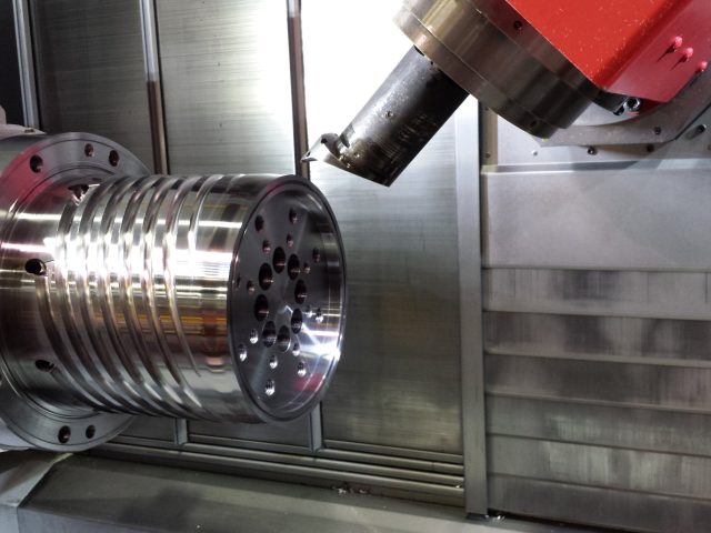 Angled milling head cutting the spiral flow channels into a mandrel on the mill-turn